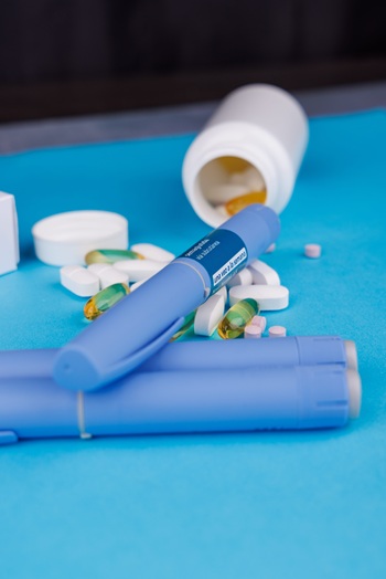 Healthcare image with scattered pills on blue surface representing wellness and lifestyle.